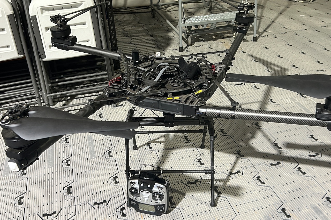 A quadcopter drone sits on the floor.