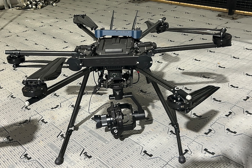 A quadcopter drone sits on the ground.
