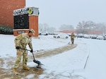 Sgt. 1st Class Marcus Harbin, Munson Army Health Center operations NCOIC, helps clear snow and ice from a sidewalk outside the facility during a winter storm, Monday, Dec. 1. Snow removal teams tended to sidewalks and parking areas for patient and staff safety as more than four inches fell on Fort Leavenworth during the day.