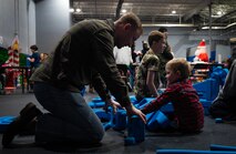 Families play together during Team Minot’s Frostival at Minot Air Force Base, North Dakota, Dec. 6, 2025. Families participated in a variety of games and activities, including a visit from Mr. & Mrs. Claus. (U.S. Air Force photo by Senior Airman Alyssa Bankston)