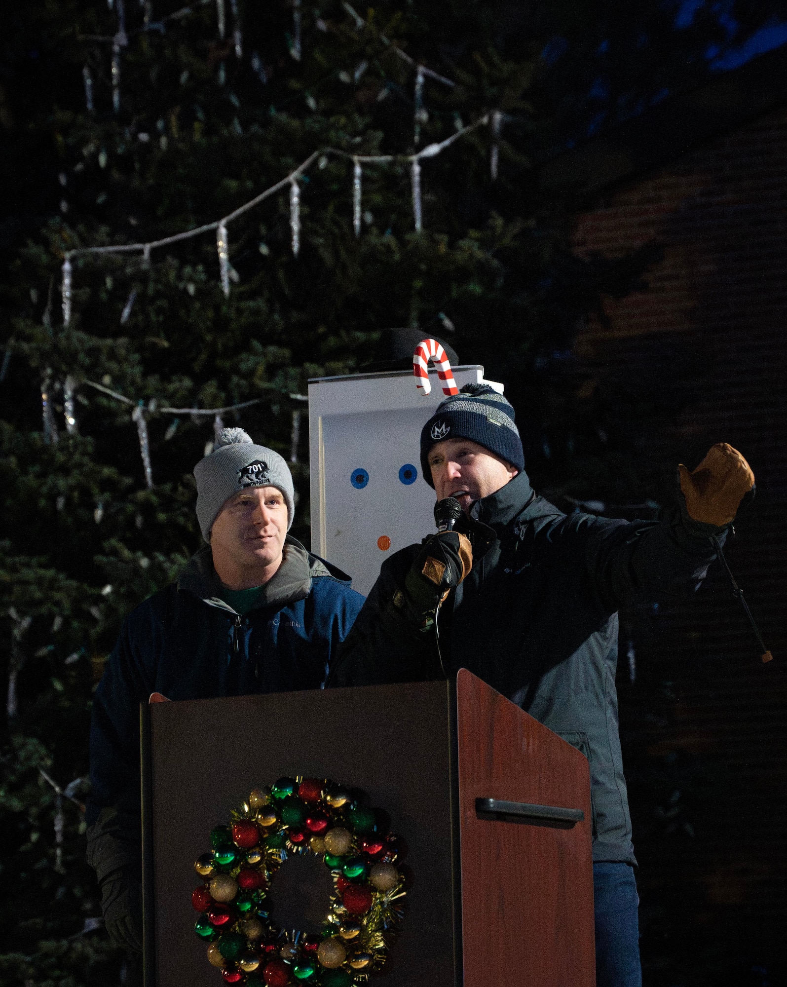 U.S. Air Force Col. Jimmy Schlabach, 91st Missile Wing commander (left), and U.S. Air Force Col. Jesse W. Lamarand, 5th Bomb Wing commander (right), address Team Minot during the Minot Air Force Base Christmas Tree Lighting at Minot AFB, North Dakota, Dec. 6, 2025. Ceremonies such as these strengthen community bonds and provide Airmen with a sense of connection and holiday cheer. (U.S. Air Force photo by Senior Airman Alyssa Bankston)
