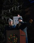 U.S. Air Force Col. Jimmy Schlabach, 91st Missile Wing commander (left), and U.S. Air Force Col. Jesse W. Lamarand, 5th Bomb Wing commander (right), address Team Minot during the Minot Air Force Base Christmas Tree Lighting at Minot AFB, North Dakota, Dec. 6, 2025. Ceremonies such as these strengthen community bonds and provide Airmen with a sense of connection and holiday cheer. (U.S. Air Force photo by Senior Airman Alyssa Bankston)
