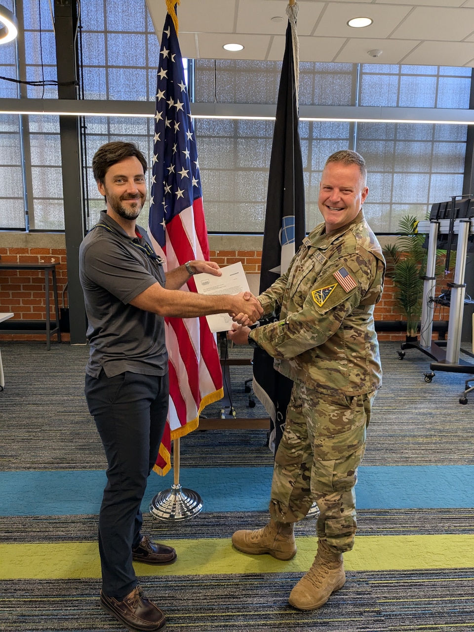 U.S. Naval Research Laboratory (NRL) Computer Engineer and TREx Product Owner Brian Cassidy (left), and Lt. Col. Brian Kester (right) from Space Systems Command (SSC) complete the transfer of the Transmit/Receive Enterprise (TREx) service from NRL to SSC in El Segundo, California, August 7, 2025. TREx was developed at NRL and will now support the broader U.S. Space Force enterprise.