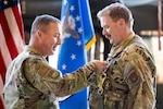 Uniformed service member pins Air Medal on another uniformed service member.