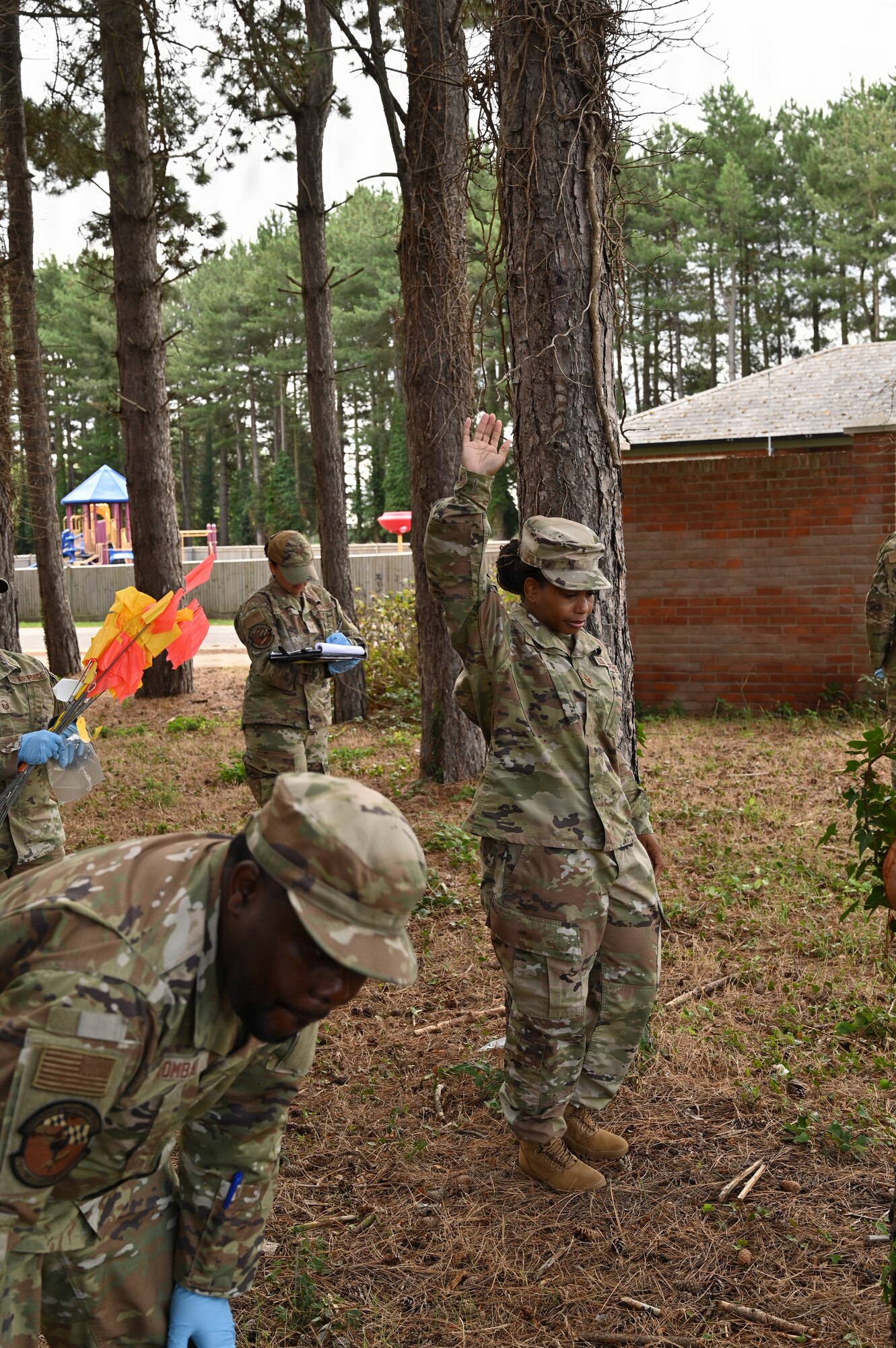Maryland Air National Guard Staff Sgt. Orlany Shelley King, a services specialist assigned to the 175th Force Support Squadron, raises her hand to signify the discovery of an object during a search and recovery training at RAF Mildenhall, England, July 22, 2025. The exercise was part of the annual training for the Force Support Squadron, where members learned the process of a search and recovery mission, including finding objects, bagging them, marking them, and working as a team to thoroughly cover a large area. (U.S. Air National Guard Photo by Staff Sgt. Alexandra Huettner)