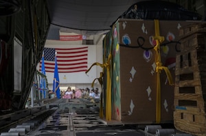 Large boxes sit inside the back of a military aircraft.