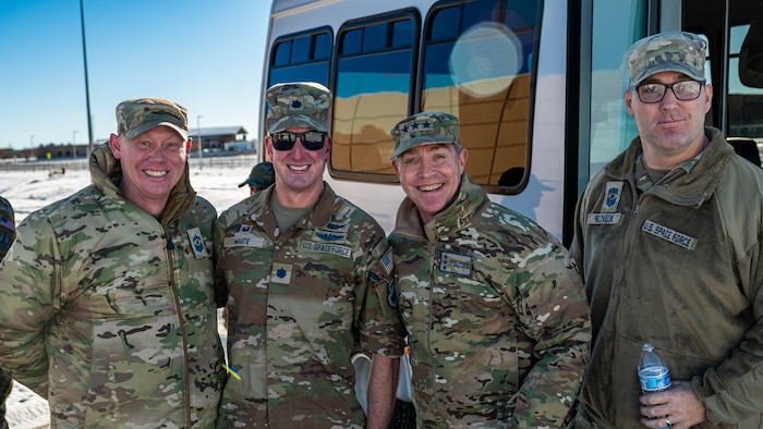 four men pose for a group photo