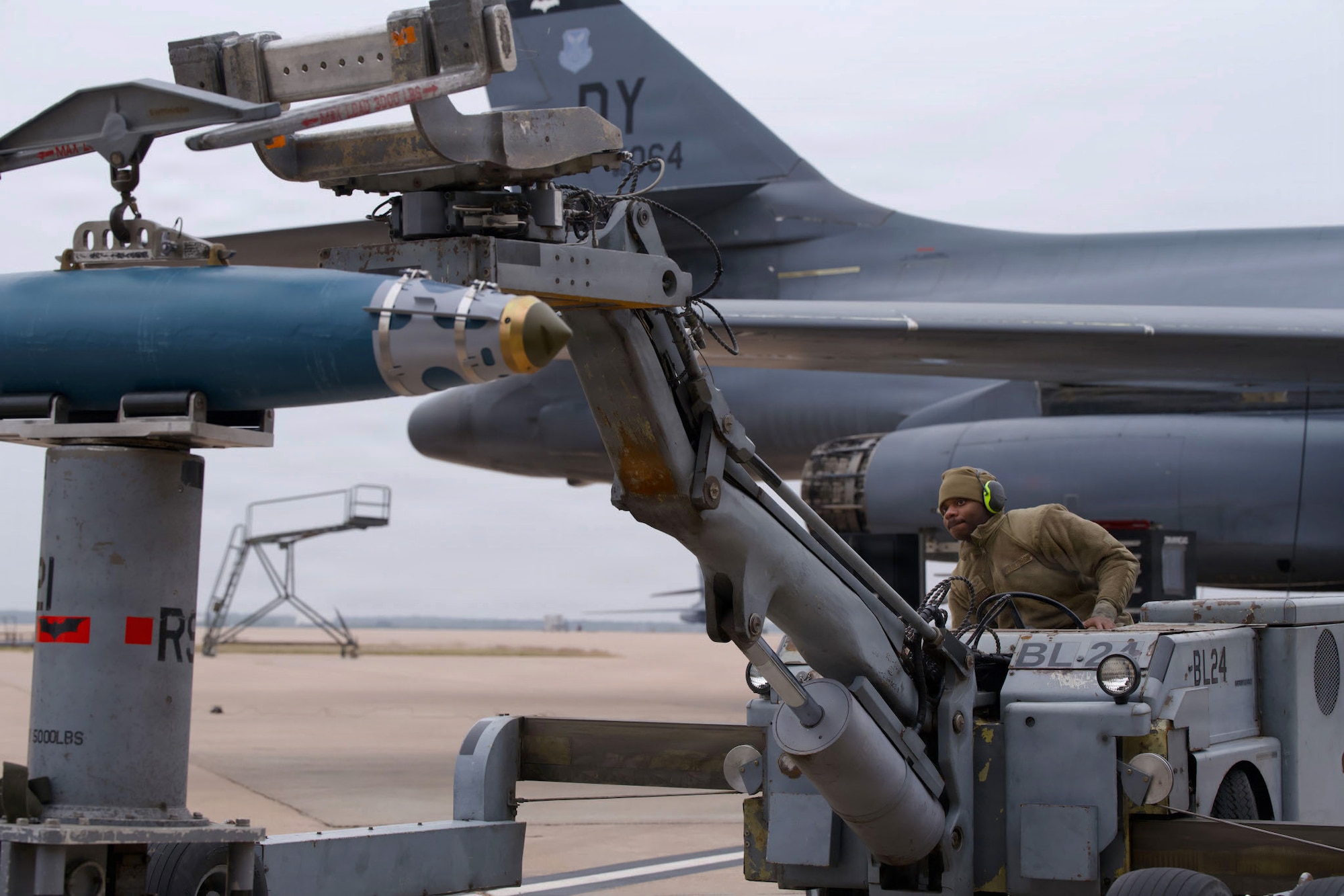 U.S. Air Force Senior Airman Demariyon Bolden, 9th Bomber Generation Squadron weapons load crew member, moves a guided bomb unit toward a B-1B Lancer during the annual Weapons Load Crew of the Year competition at Dyess Air Force Base, Texas, Dec. 4, 2025.  Teams were tested on a variety of technical aspects of munitions loading while under time constraints. (U.S. Air Force photo by Senior Airman Emma Anderson)