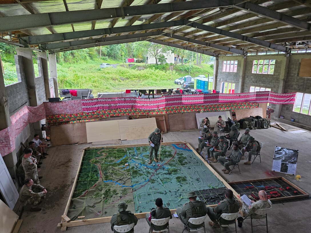 LT Lakoenavuli, Fiji Royal Military Forces, company commander, briefs the "culminating raid" during Exercise Cartwheel, Nov. 6, 2025. Showcasing the Terrain Model, creating situational awareness, and clearly communicating the concept of the operation, this brief drove the following days rehearsals and enhanced the execution of the raid.