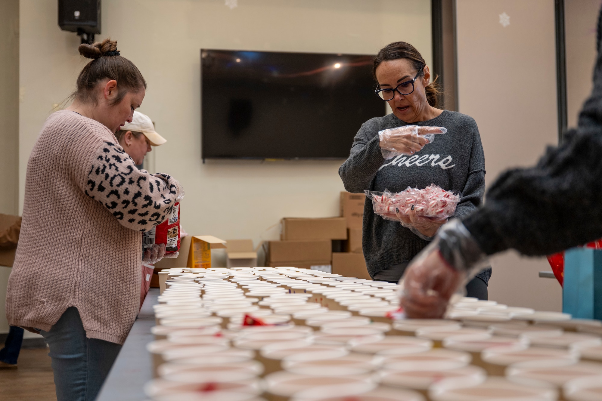 Volunteers assemble holiday care packages for unaccompanied Airmen in dorms at Osan Air Base, Republic of Korea, Dec. 8, 2025.