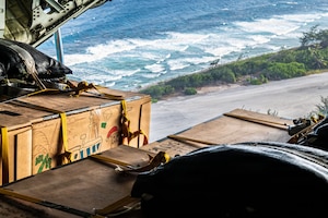 A person waving over the open ramp of an aircraft