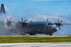 A C-130 aircraft is sprayed down.
