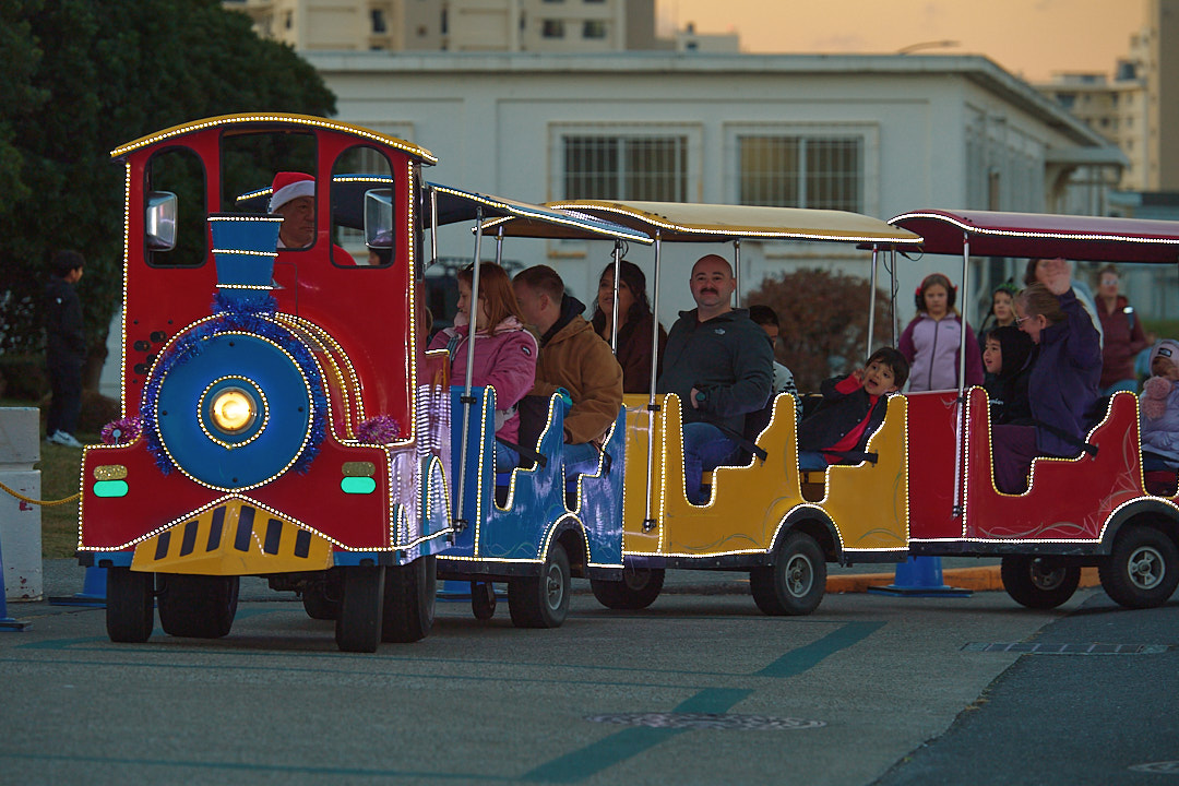 Commander, Fleet Activities Yokosuka (CFAY) family members ride a train through the Commissary parking lot during a tree lighting ceremony and festival at the installation, Dec. 5, 2025.