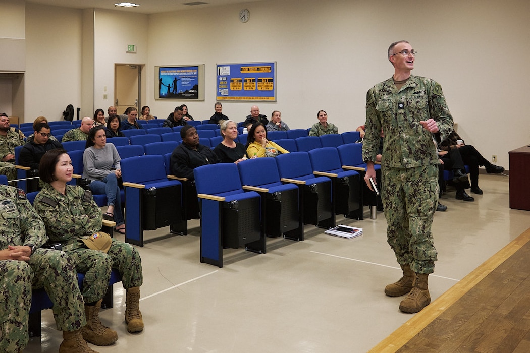 Cmdr. Andrew Cotherman, Commander, Fleet Activities Yokosuka’s (CFAY) Public Works Officer, shares upcoming unaccompanied housing and parking garage construction projects at the CFAY Town Hall in the Community Readiness Center December 9, 2025.