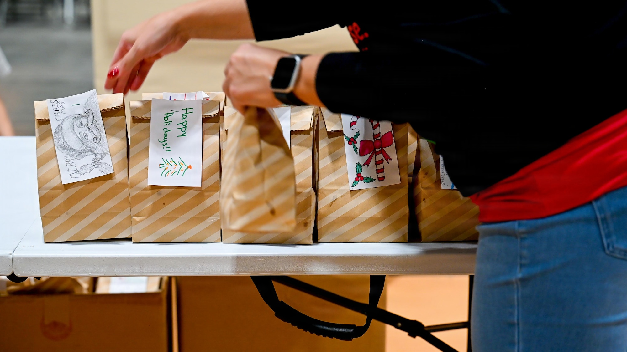 A volunteer places goodie bags onto a table during the 2025 Cookie Caper event.