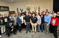 Army Maj. Gen. Eric Shirley, U.S. Army Sustainment Command’s commanding general, and Command Sgt. Maj. Jason Gusman, ASC’s senior enlisted leader, (center) pose for a group photo with the 405th Army Field Support Brigade team at their holiday celebration event at the brigade headquarters in Kaiserslautern, Germany, Dec. 9.