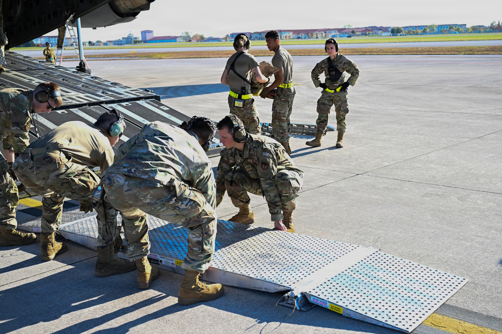 Airmen lift a loading ramp.