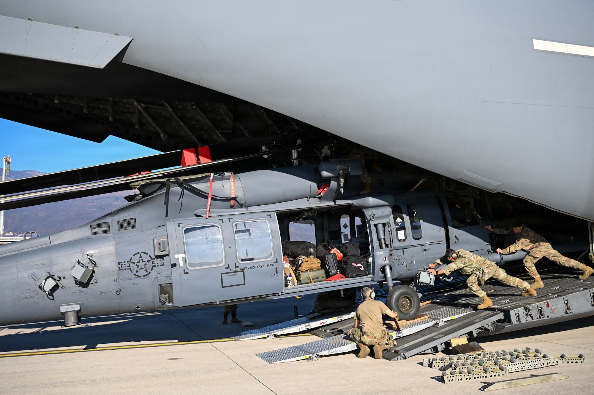 Airmen offload a helicopter.