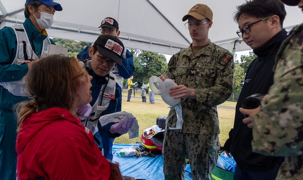 JOGASHIMA PARK, Japan (Nov. 9, 2025) — A U.S. Navy Hospital Corpsman assigned to U.S. Navy Medicine Readiness and Training Command Yokosuka works with Japanese responders to assess and treat a simulated casualty during Big Rescue Kanagawa 2025. The annual exercise is one of Kanagawa Prefecture’s largest disaster-response drills, involving U.S. Naval Hospital Yokosuka, Red Cross Yokosuka and Branch Health Clinic Atsugi personnel working alongside U.S. and Japanese agencies. (U.S. Navy photo by Daniel Taylor/USNMRTC Public Affairs)