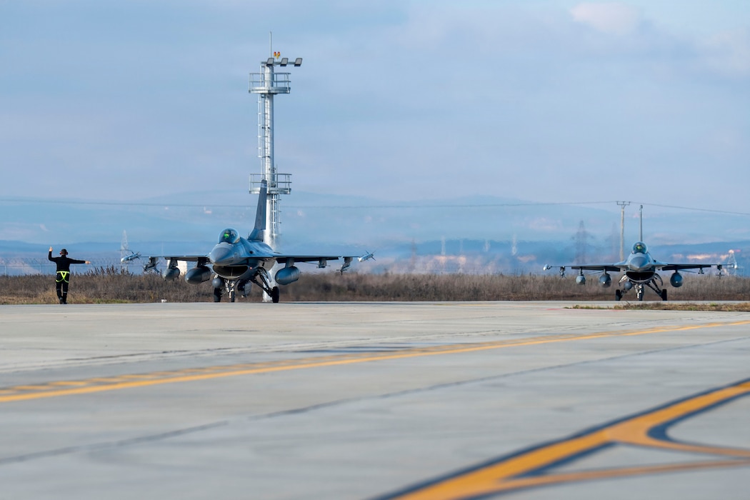 Two U.S. Air Force F-16 Fighting Falcons, assigned to the 510th and 555th Fighter Generation Squadrons at Aviano Air Base, Italy, taxi down the runway during routine Agile Combat Employment operations at Campia Turzii, Romania