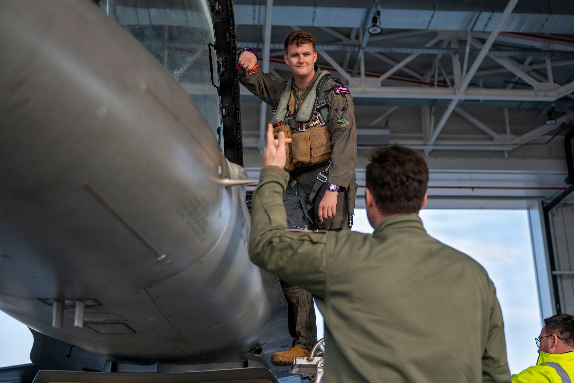 U.S. Air Force Capt. Kenneth Roberts, 510th Fighter Squadron F-16 Fighting Falcon pilot, speaks with a Romanian Air Force F-16 pilot before taking off from Campia Turzii, Romania