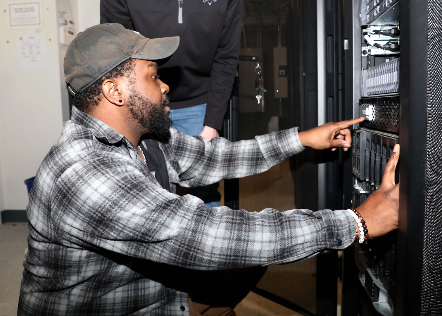 Photo of an IT specialist conducting a check of a server system.
