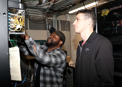 Photo of IT specialists conducting a check of a server system.