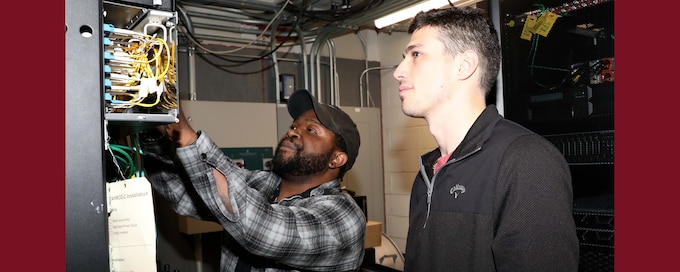 Photo graphic of IT specialists conducting a check of a server system.