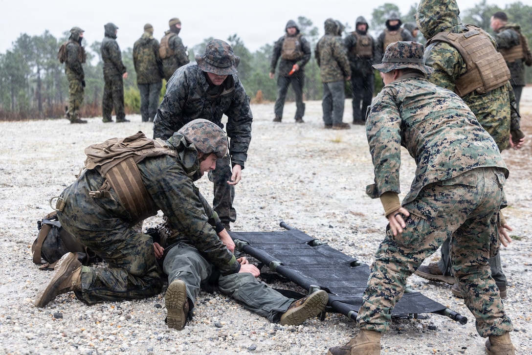 U.S. Marines and sailors with 2nd Assault Amphibian Battalion, 2nd Marine Division conduct a simulated casualty evacuation during Naval Integration Training Package 2 on Marine Corps Base Camp Lejeune, North Carolina, Dec. 5, 2025. NITP-2 is a part of a larger training evolution certifying amphibious combat vehicle crewmen to safely and properly conduct combat operations with the ACV. (U.S. Marine Corps photo by Cpl. Grace Stover)