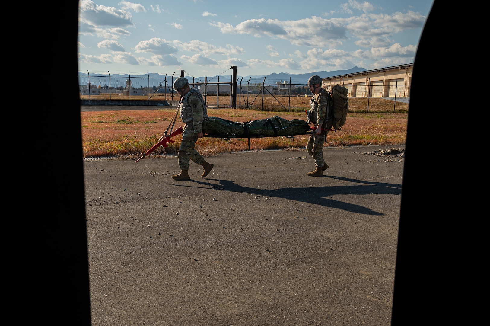 Two Airmen carry a stretcher.