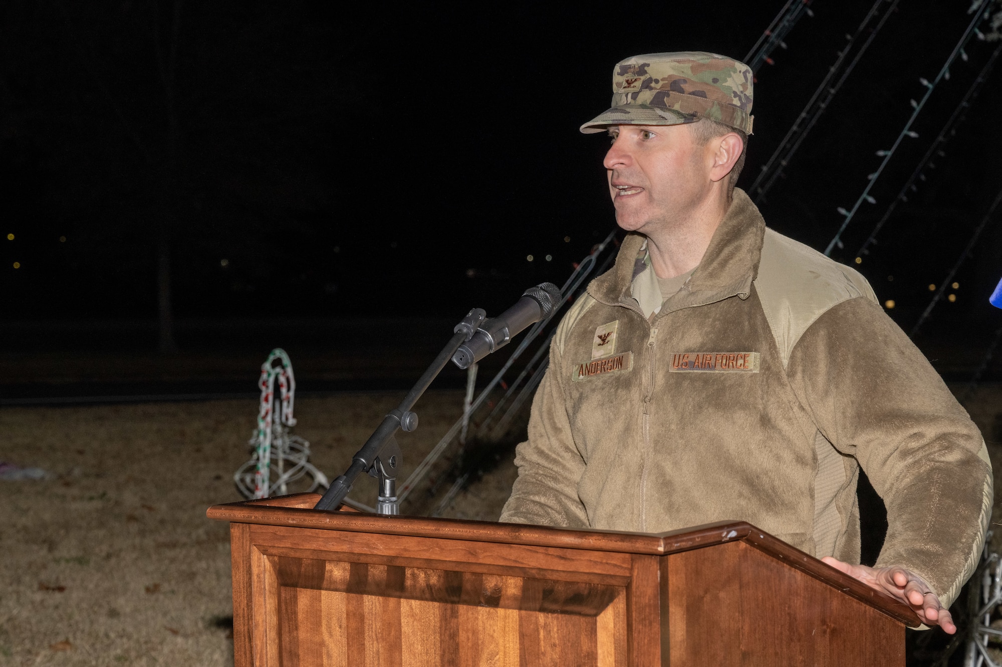 A man stands at a podium and speaks into a microphone.