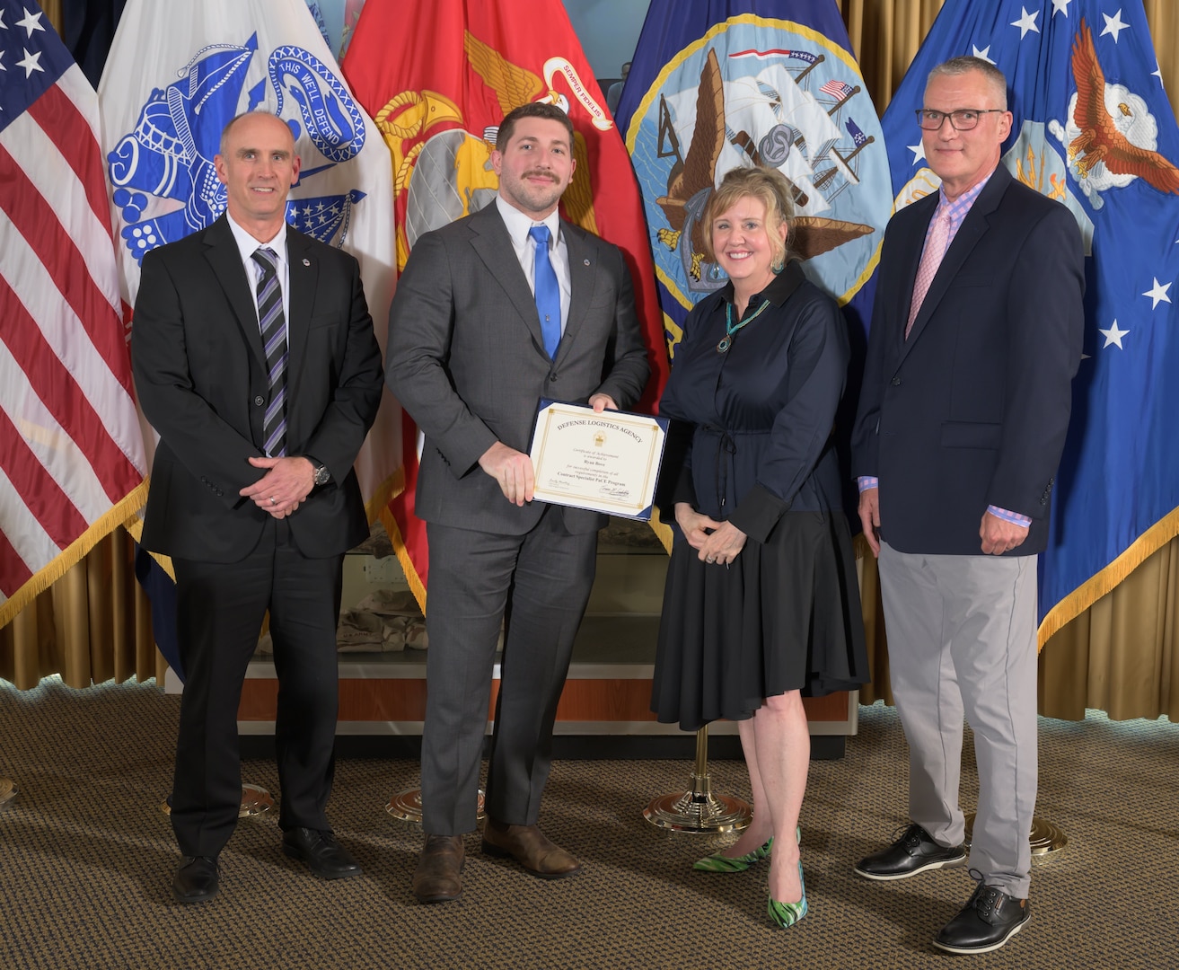 Ryan Bove (center left) receives his PaCE graduate certificate presented by Mr. George Atwood (left), DLA Training Director Teresa Geduldig (center right) and DLA Energy Deputy Director of Supplier Operations Kevin Ahern (right).