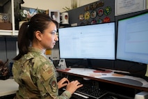 An Airman seated at a desk, working.