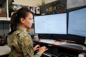 An Airman seated at a desk, working.