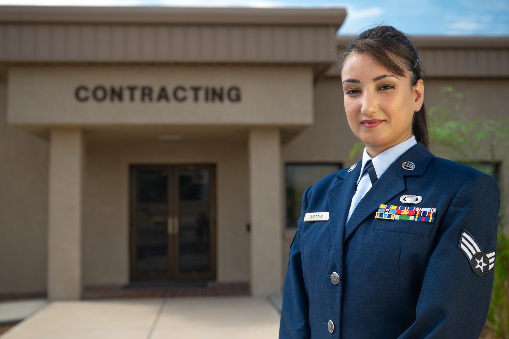 An Airman standing in front of a contracting building.