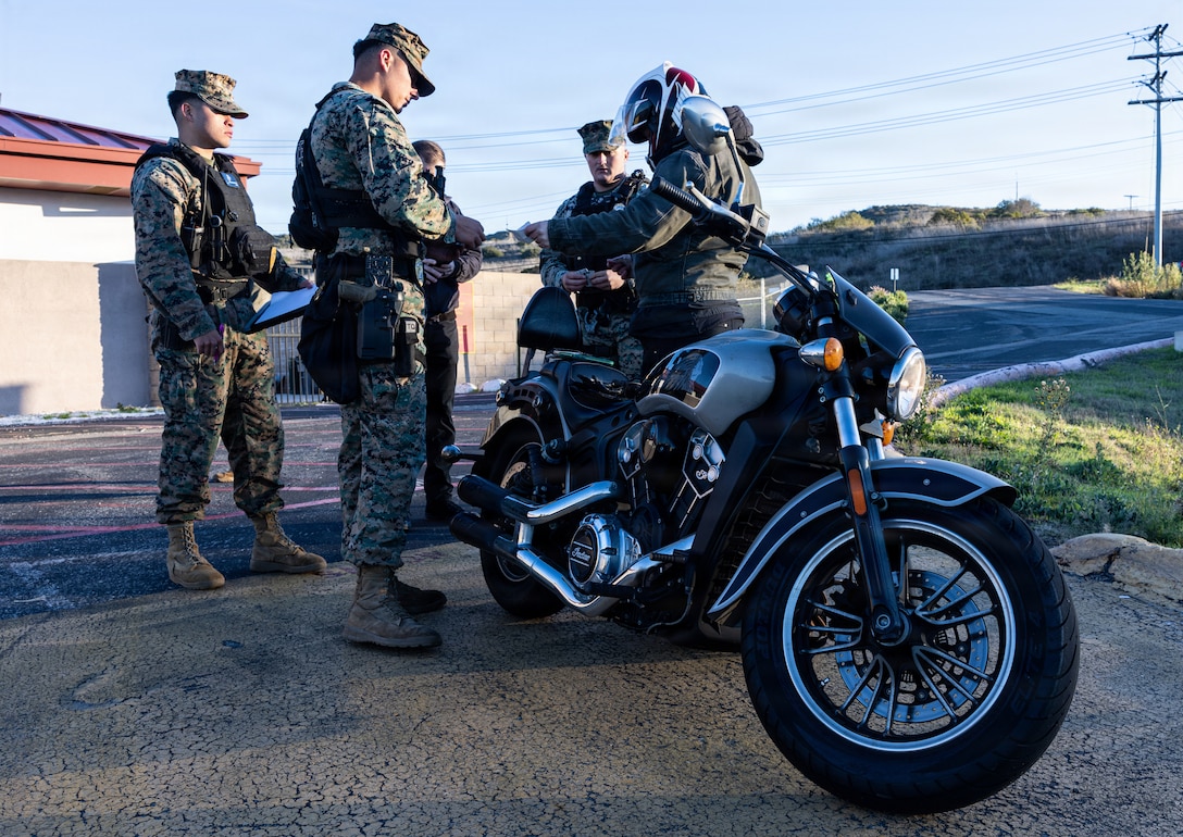 U.S. Marines and civilians with the Provost Marshal's Office with Headquarters and Support Battalion conduct personal protective equipment, registration, and insurance inspections during Operation Full Stop at Marine Corps Base Camp Pendleton, California, Dec. 1, 2025. Operation Full Stop is designed to ensure 100% compliance with motorcycle personal protective equipment and legal regulations. (U.S. Marine Corps photo by Cpl. Jacqueline Akamelu)