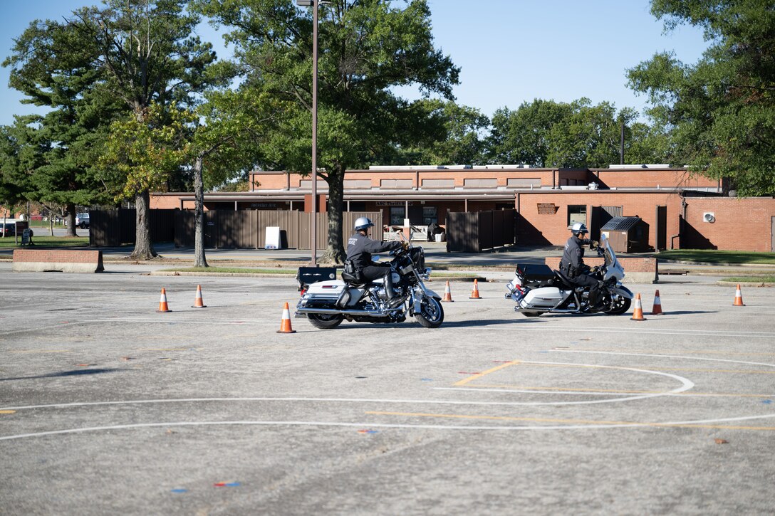 Police officers ride motorcycles around traffic cones.