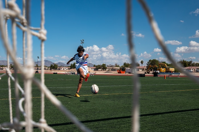 A person demonstrates a rugby drill on a soccer field.
