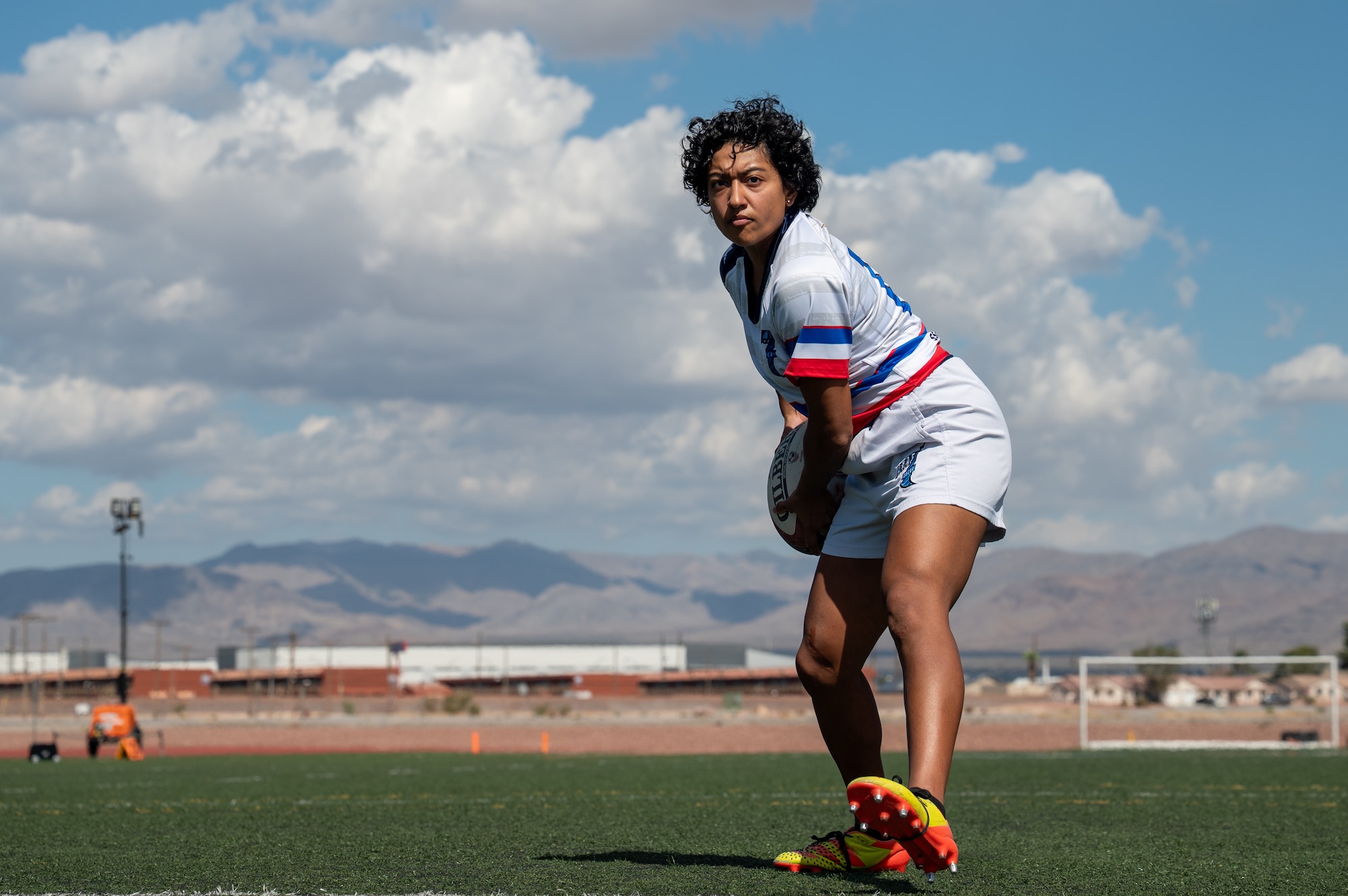 A person demonstrates a rugby drill on a soccer field.