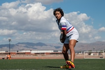 A person demonstrates a rugby drill on a soccer field.