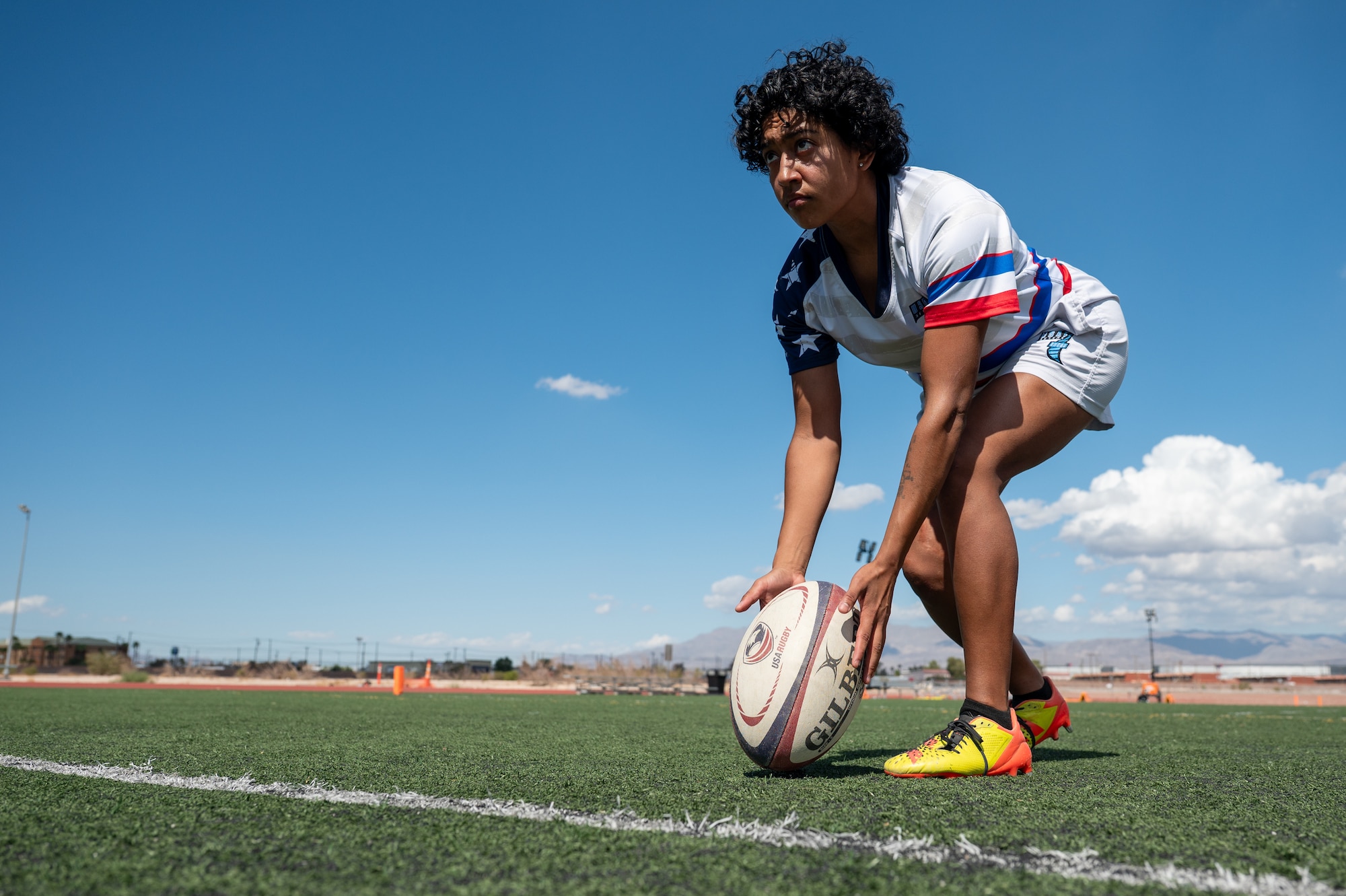 A person demonstrates a rugby drill in a soccer field.