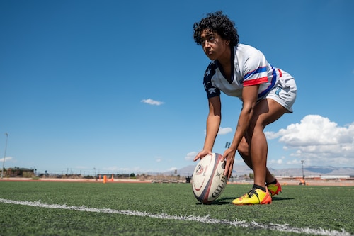 A person demonstrates a rugby drill in a soccer field.