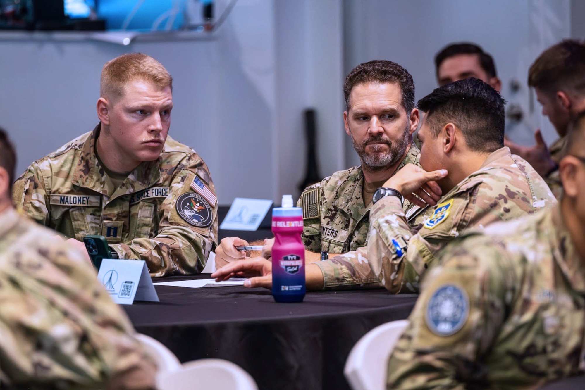 Three men discuss the answer to a problem at a table