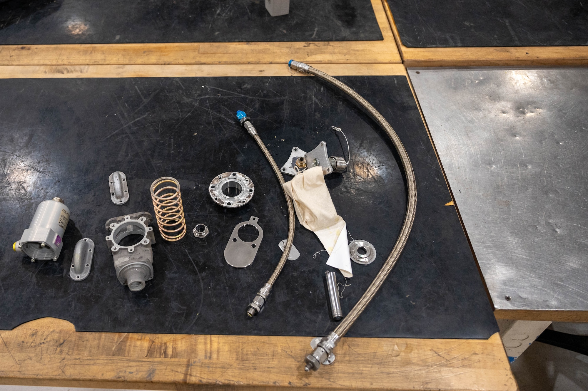 KC-46 fuel valve parts are arranged on a table Dec. 1, 2025, at McConnell Air Force Base, Kansas. This valve ensures the fuel is retracted back into the KC-46 before the boom is stowed during flight. (U.S. Air Force photo by Senior Airman William Lunn)