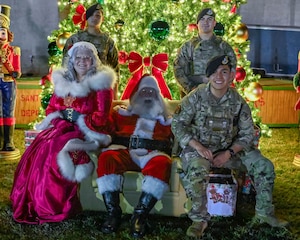 Santa Claus and Mrs. Claus pose for a photo, with the 56th Fighter Wing defenders, Dec. 5, 2025, at Luke Air Force Base, Arizona.