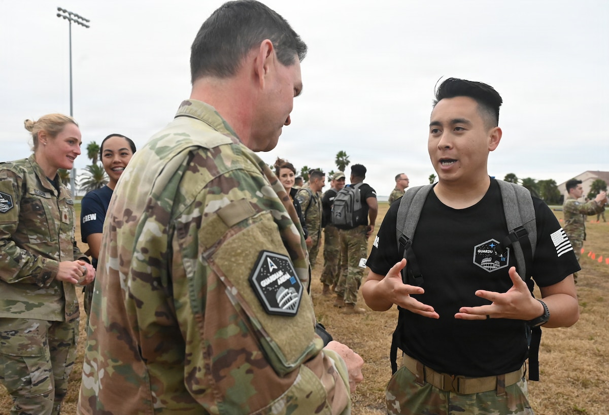 Chief of Space Operations Gen. Chance Saltzman talks with a Guardian Arena competitor at Patrick Space Force Base, Fla., Dec. 9, 2025. Thirty-five teams, comprised of U.S. Space Force Guardians, U.S. Air Force Airmen, civilians, and representatives from international allies and partners, took part in the world’s largest Space Force exercise. The competition emphasizes the importance of cultivating a combat-ready mindset, connecting military and civilian space enterprises, and building esprit de corps by putting the Guardian Ideals into action. (U.S. Air Force photo by Chad Trujillo)