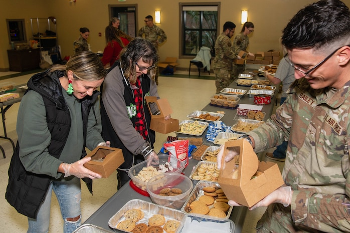 A photo of an Airman and volunteers packaging cookies.