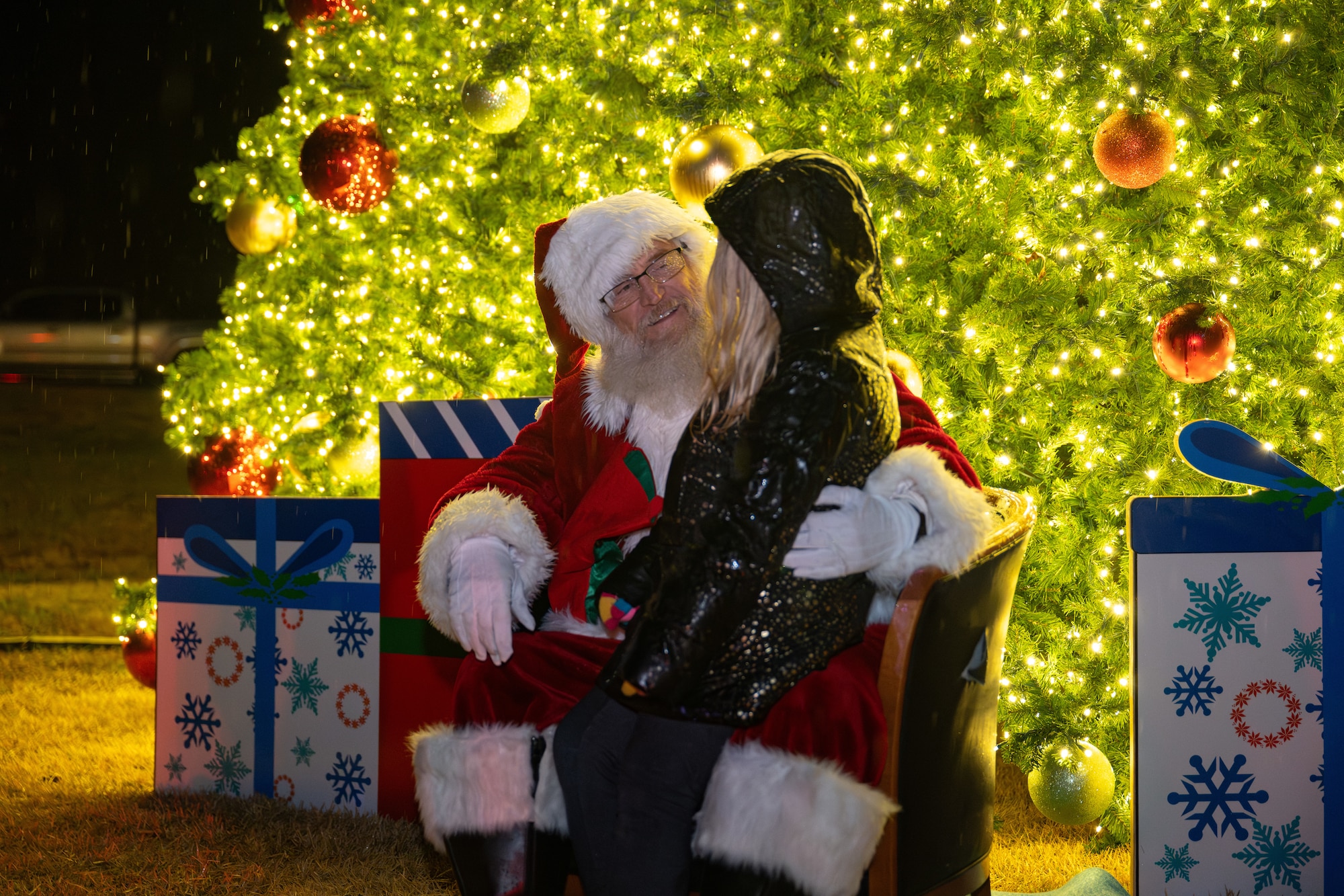 Santa, portrayed by Joe Owens, was on hand to hear the holiday wishes of young attendees during the Arnold Air Force Base Christmas tree lighting Dec. 4, 2025. The Christmas tree at Arnold AFB, Tenn., headquarters of AEDC, was purchased in 2023 after installation leadership expressed a desire for a Christmas tree to be displayed at a prominent location on the base. The tree measures 40 feet tall and 22 feet wide. It is decorated with approximately 300 ornaments and is topped with a 5-foot 3D five-point star. (U.S. Air Force photo by Keith Thornburgh)