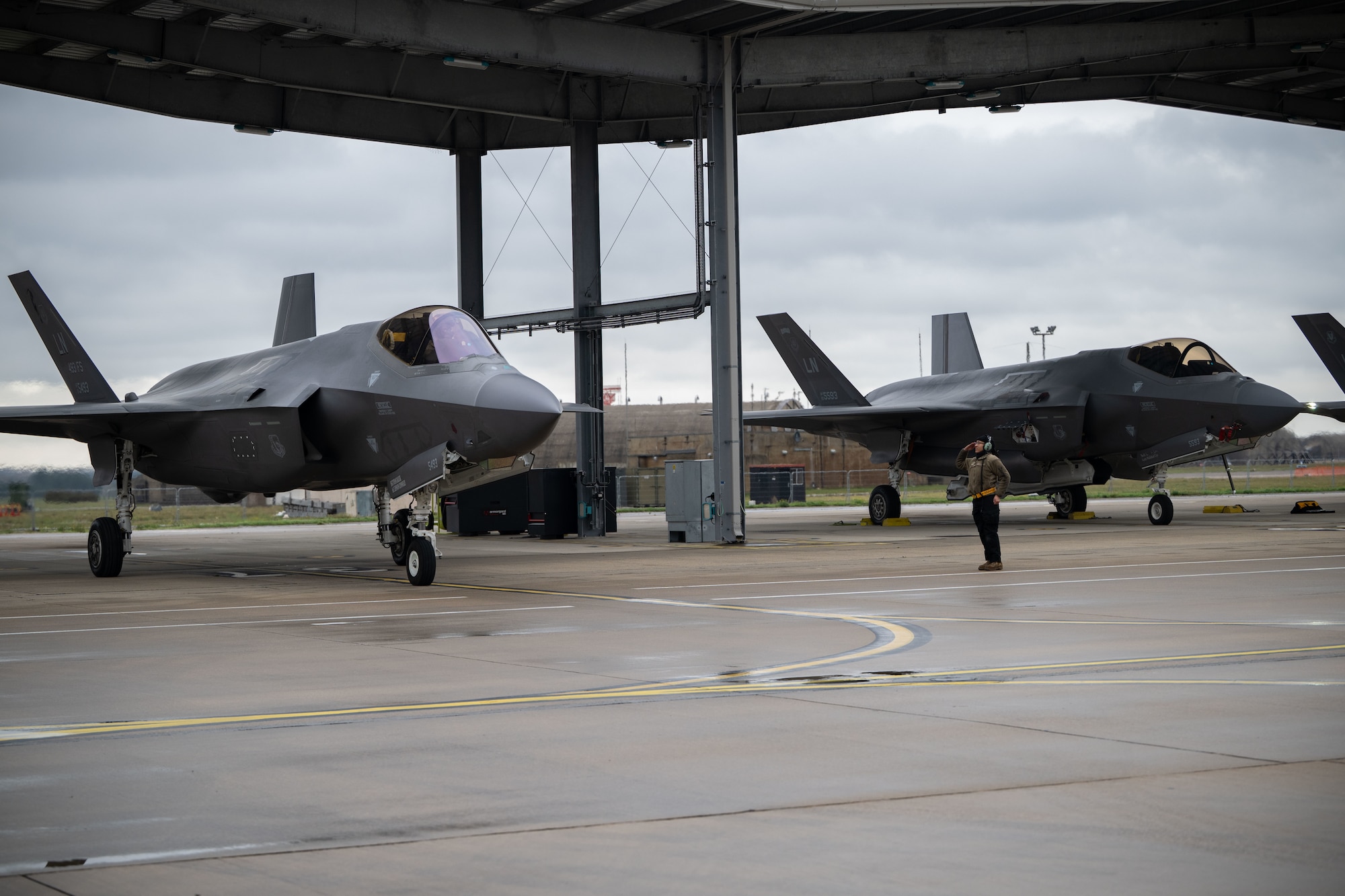 U.S. Air Force Airman 1st Class Angelina Alvarez, 493rd Fighter Generation Squadron crew chief, prepares to marshal a F-35 Lightning II at RAF Lakenheath before a training mission across the Baltic states