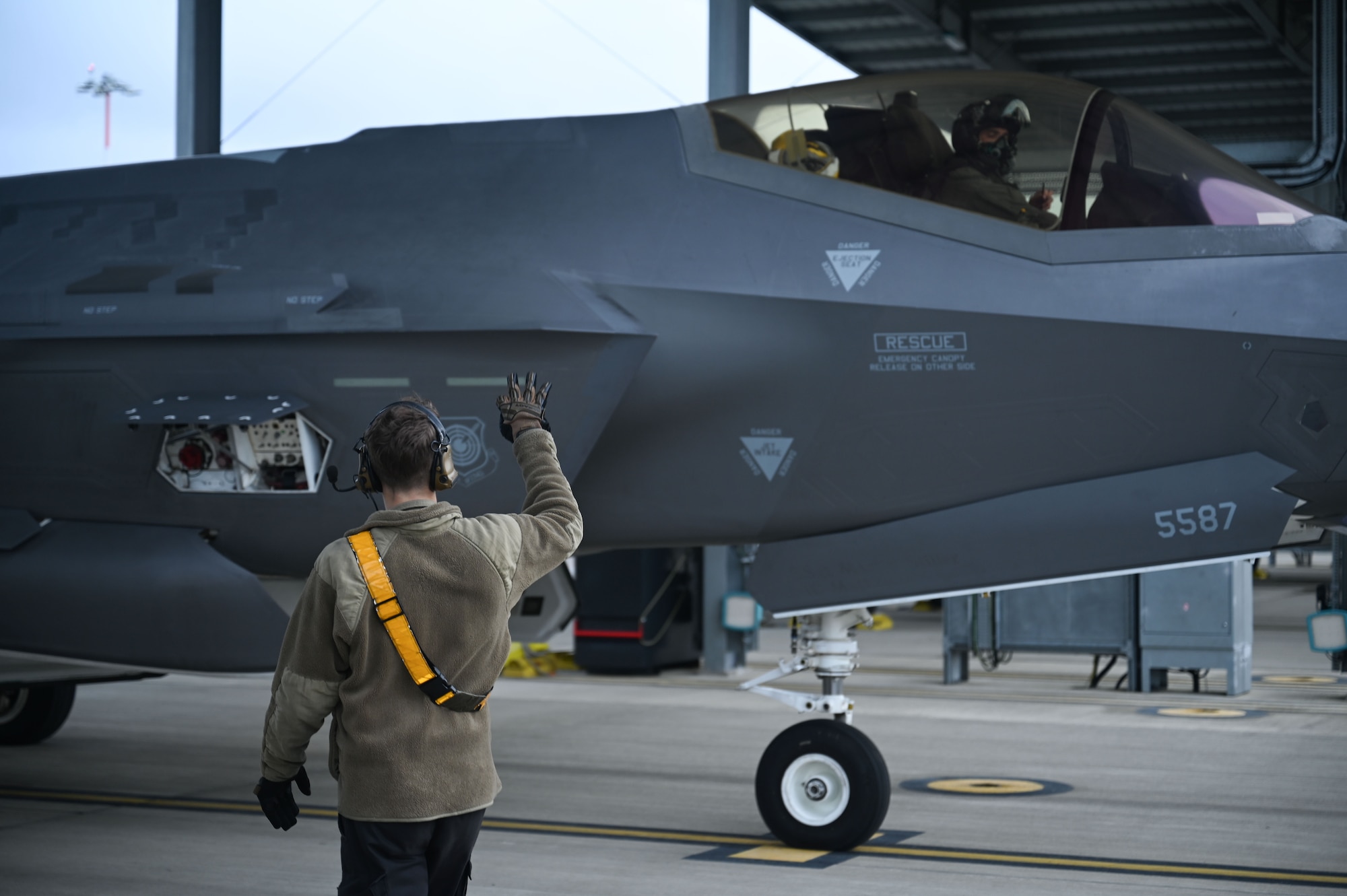 U.S. Air Force Senior Airman Jayden Archuleta, 493rd Fighter Generation Squadron crew chief, communicates with the pilot of a F-35 Lightning II aircraft before a training mission over the Baltic states from RAF Lakenheath